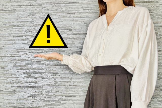 注意マークとそれを示す女性