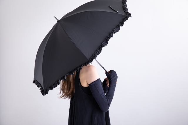 黒い日傘をさす女性