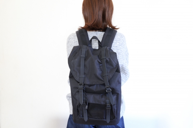 黒いリュックを背負ってる女性の後ろ姿